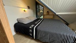 a bed in a small room with a staircase at Le Cocon Cap Forêt in Lège-Cap-Ferret