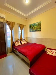 1 dormitorio con cama roja y ventana en TAMA Guesthouse 15 People for Family or Group, en Tangerang