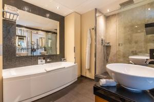 a bathroom with a tub and a sink and a bath tub at Five Seas by Inwood Hotels in Cannes