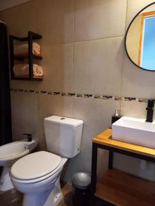 Un baño con un inodoro blanco y un lavabo. en Departamento 2448, en Mina Clavero