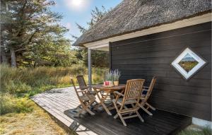 a table and chairs on a deck next to a building at Holiday Home Lærkestien in Skagen