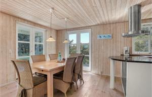 スケーエンにあるNice Home In Skagen With Kitchenのキッチン、ダイニングルーム(木製のテーブルと椅子付)