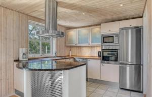 a kitchen with white cabinets and a stainless steel appliance at Holiday Home Lærkestien in Skagen