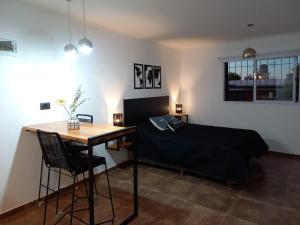 Un dormitorio con una cama, un escritorio y una mesa. en Departamento 2448, en Mina Clavero