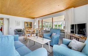 una sala de estar con sofás azules y una mesa. en 3 Bedroom Awesome Home In Hjrring, en Hjørring
