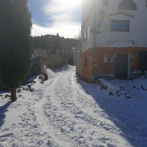 eine schneebedeckte Straße vor einem Gebäude in der Unterkunft Preciosa casita rural en la sierra de Segur a, Cazorla y las Villas in Santiago-Pontones
