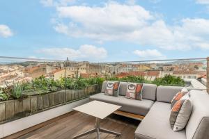 a balcony with a couch and a view of the city at Five Seas by Inwood Hotels in Cannes