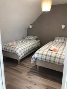 two twin beds in a room with wood floors at Le champ des granges in Briare