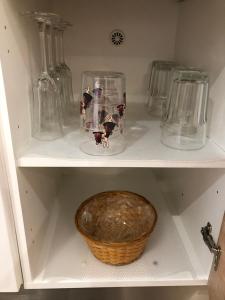 a shelf with glass vases and a bowl on it at Le champ des granges in Briare