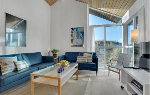 a living room with a blue couch and a table at Beautiful Home In Skagen With 3 Bedrooms, Sauna And Wifi in Hulsig