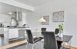 a kitchen and dining room with a table and chairs at One-Bedroom Apartment In Romo in Havneby +18 photos