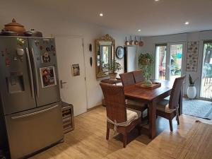 a kitchen and dining room with a table and a refrigerator at Maison agréablement chaleureuse in Albi