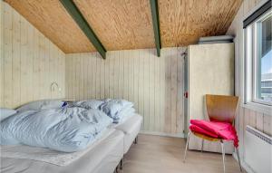 ロンストラップにあるPet Friendly Home In Hjrring With House Sea Viewのベッド1台、椅子、窓が備わる客室です。