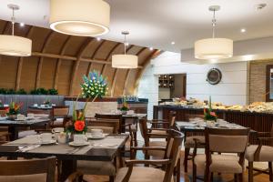 a restaurant with tables and chairs and a buffet at Hotel Dann Carlton Bogota in Bogotá
