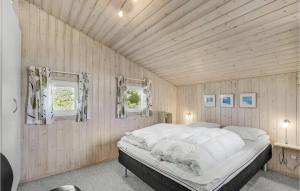 ロンストラップにあるStunning Home In Hjrring With 3 Bedrooms, Sauna And Wifiの木製の壁に大きなベッドが備わるベッドルーム1室