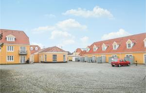 a red car parked in front of a building at Two-Bedroom Apartment In Lokken in Løkken
