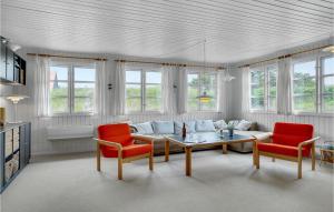a living room with a couch and two red chairs at Three-Bedroom Holiday Home In Skagen in Skagen