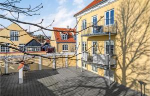 un gran edificio amarillo con balcones y un patio en Gorgeous Apartment In Skagen With Kitchen, en Skagen