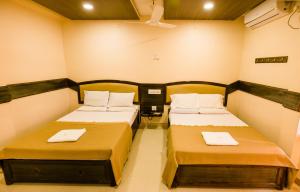 HiriyūrNEW HOTEL SURYA LODGE的一间设有两张床的客房,