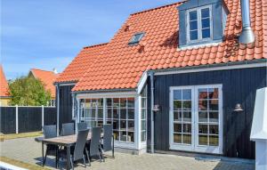 una casa con tavolo, sedie e tetto di Awesome Home In Skagen With Kitchen a Skagen