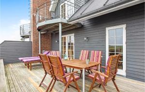 a wooden table and chairs on a deck at Holiday Home Vestergade Rømø in Rømø Kirkeby +14 photos
