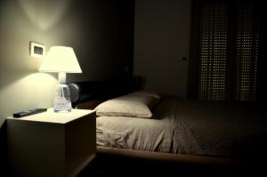 モンテジルヴァーノにあるappartamento libraのベッドルーム1室(ベッド1台、ナイトスタンドのランプ付)
