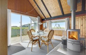 ロンストラップにあるBeautiful Home In Hjrring With 3 Bedrooms And Wifiのダイニングルーム(暖炉、テーブル、椅子付)