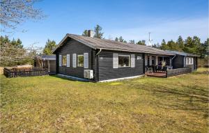 a black house with a yard in front of it at Cozy Home In Bindslev With Wifi in Terpet