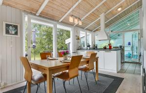 uma cozinha e sala de jantar com uma mesa de madeira e cadeiras em Cozy Home In Bindslev With Wifi em Bindslev
