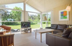 sala de estar con sofá y mesa en Nice Home In Lkken With 3 Bedrooms, Sauna And Wifi en Løkken