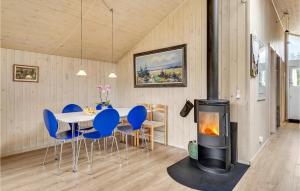 une salle à manger avec une table, des chaises et une cheminée dans l'établissement Nice Home In Lkken With Indoor Swimming Pool, à Trudslev