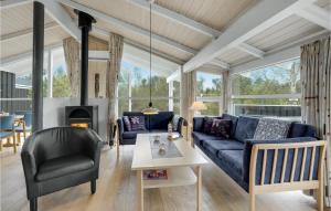 ÅlbækにあるAmazing Home In lbk With 4 Bedrooms, Sauna And Wifiのリビングルーム(青いソファ、椅子付)