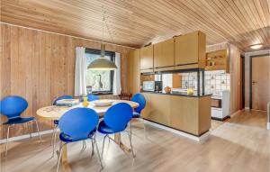 a kitchen and dining room with a table and blue chairs at Awesome Home In Blvand With 3 Bedrooms in Blåvand