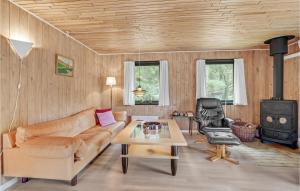 a living room with a couch and a stove at Awesome Home In Blvand With 3 Bedrooms in Blåvand