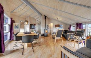 a living room with a couch and a table and chairs at Holiday Home Rauhesvej Ix in Bjerregård