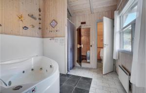 a large bathroom with a tub and a window at Holiday Home Rauhesvej Ix in Bjerregård +19 photos