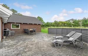 a patio with chairs and a grill in front of a house at Stunning Home In Rm With Kitchen in Rømø Kirkeby