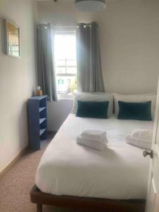 een slaapkamer met een bed met 2 kussens en een raam bij 2-bedroom cottage in heart of St Ives w/ parking in St Ives