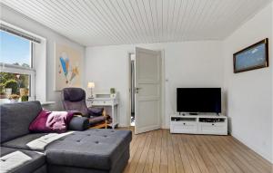uma sala de estar com um sofá e uma televisão de ecrã plano em 5 Bedroom Amazing Home In Strandby em Strandby