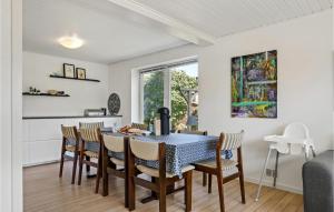 5 Bedroom Amazing Home In Strandby في Strandby: غرفة طعام مع طاولة وكراسي