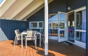 a porch with a table and chairs on a deck at Amazing Home In Ringkbing With 3 Bedrooms, Sauna And Wifi in Søndervig