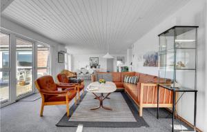 BjerregårdにあるLovely Home In Hvide Sande With Saunaのリビングルーム(ソファ、テーブル付)