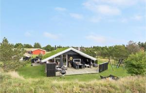 a large house with a grass roof on a field at Nice Home In Blvand With 3 Bedrooms And Wifi in Blåvand