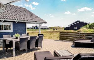 BjerregårdにあるGorgeous Home In Hvide Sande With Kitchenのパティオ(テーブル、椅子付)