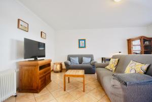 sala de estar con 2 sofás y TV de pantalla plana en Catarina House - Baleal Beach, Balcony, Pool, en Ferrel