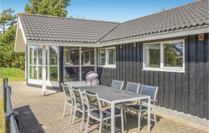 a table and chairs in front of a house at Holiday Home Gl Mælkevej Xii in Blåvand