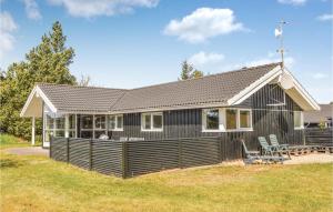 a black house with a deck in the yard at Holiday Home Gl Mælkevej Xii in Blåvand