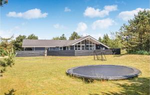 a house with a trampoline in front of a yard at Stunning Home In Blvand With 4 Bedrooms, Sauna And Wifi in Blåvand
