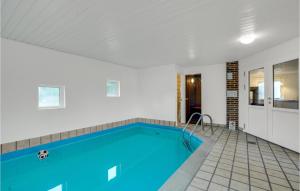 an indoor swimming pool with blue water in a house at Awesome Home In Blvand With 5 Bedrooms, Sauna And Indoor Swimming Pool in Ho