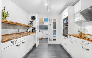 una cucina con armadietti bianchi e pavimento piastrellato di Pet Friendly Home In Blåvand With Wifi a Blåvand